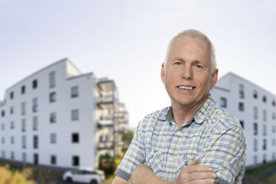 Ein Mitarbeiter vor zwei Gebäuden.